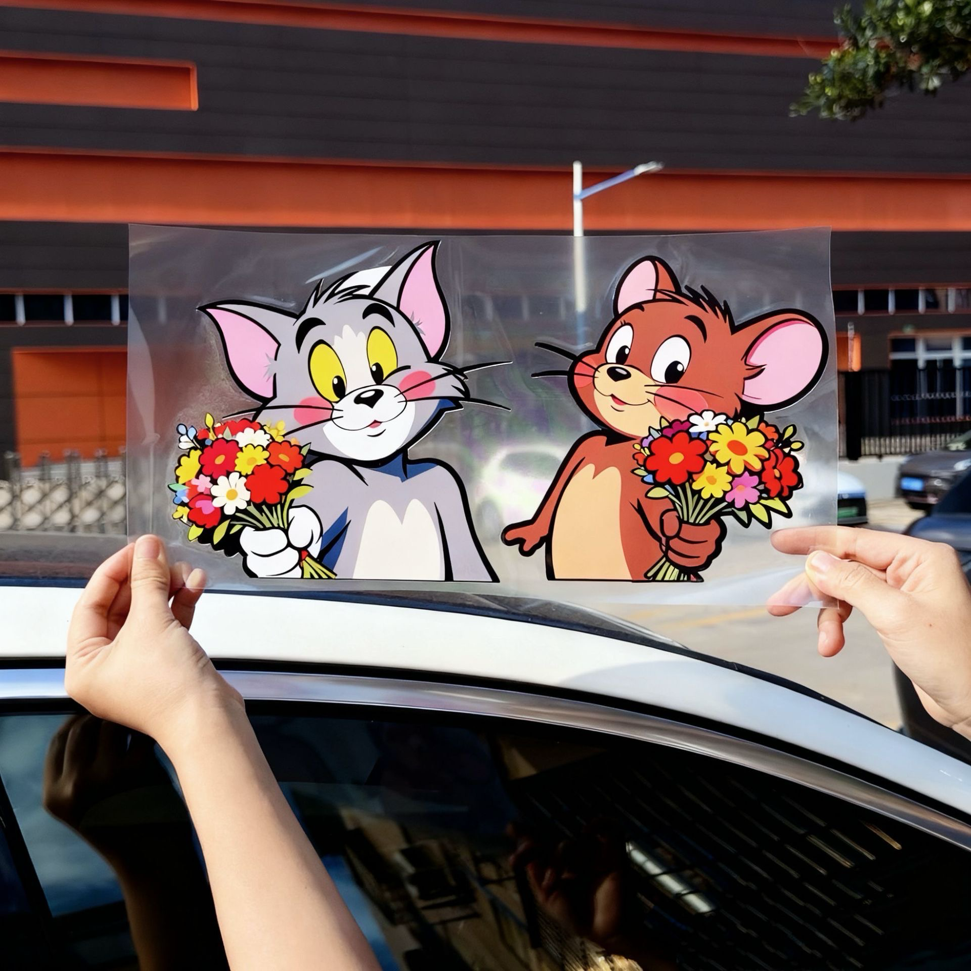 Easy peel-and-stick application of Tom and Jerry vinyl decals for car windows and glass.