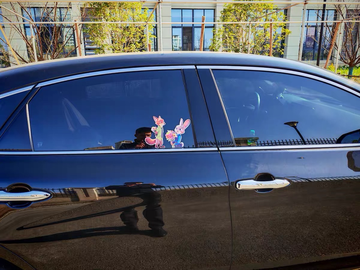 Car window with cartoon character stickers in a residential area