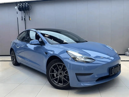 Blue car on a white floor with a gray wall background