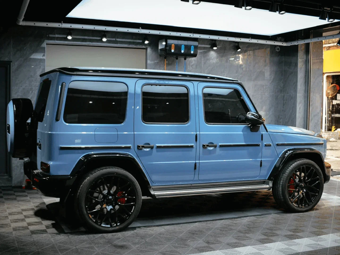 Blue SUV with black rims in a showroom setting